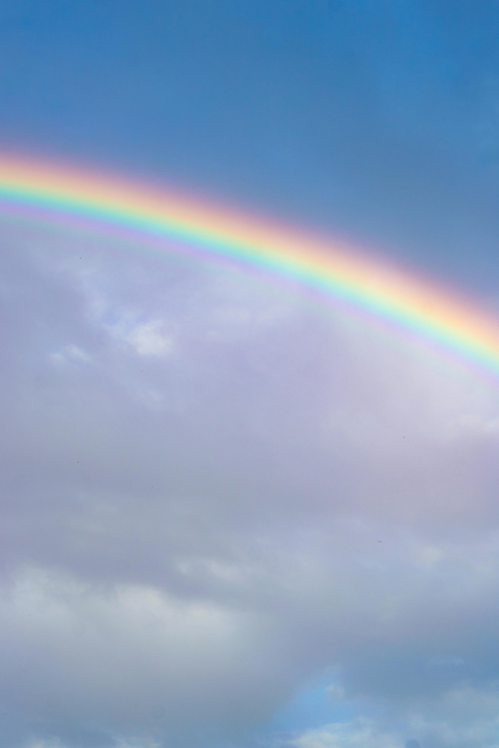 Soft rainbow emerging through layered clouds, symbolizing clarity and momentum in accelerated therapy.